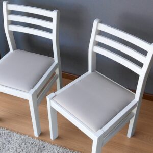 two white chairs next to a wall