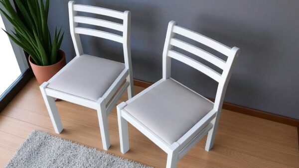 two white chairs next to a wall