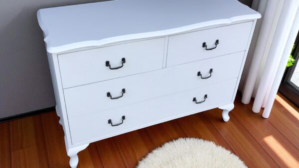 a white dresser with black handles