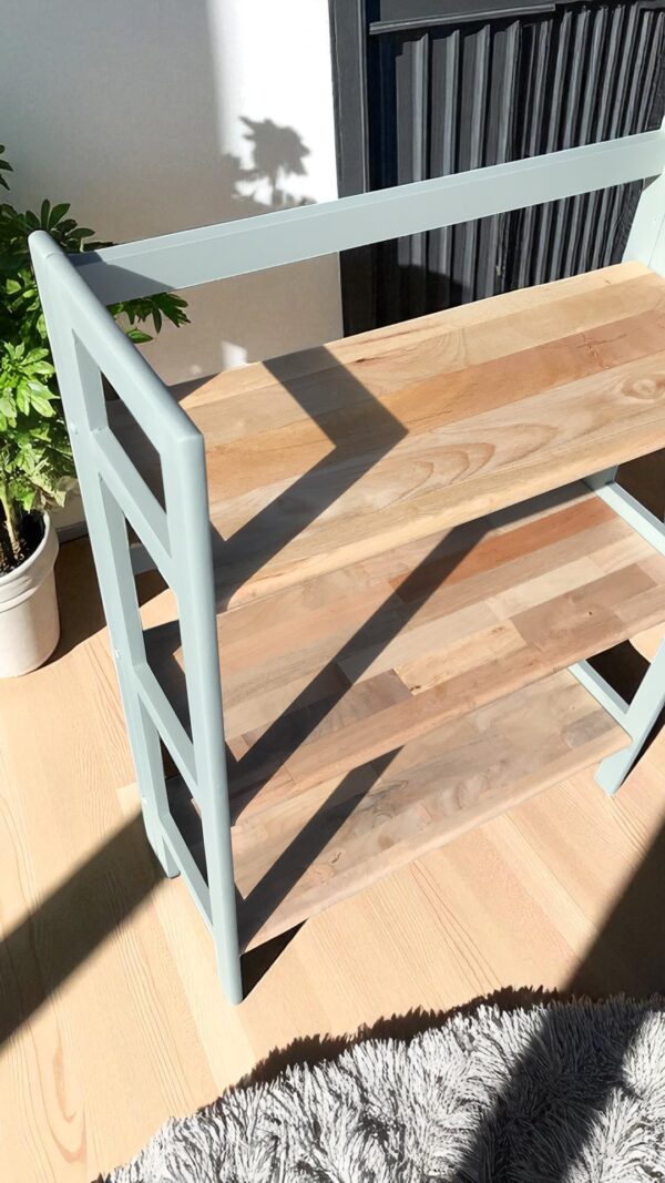 a wood shelf with a plant in the background