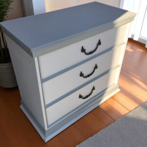 a white dresser with black handles