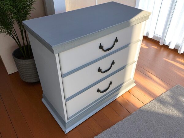 a white dresser with black handles